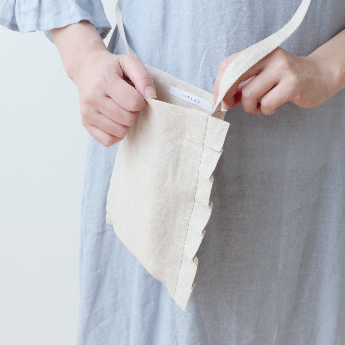 Linen pochette with tuck frills and beads