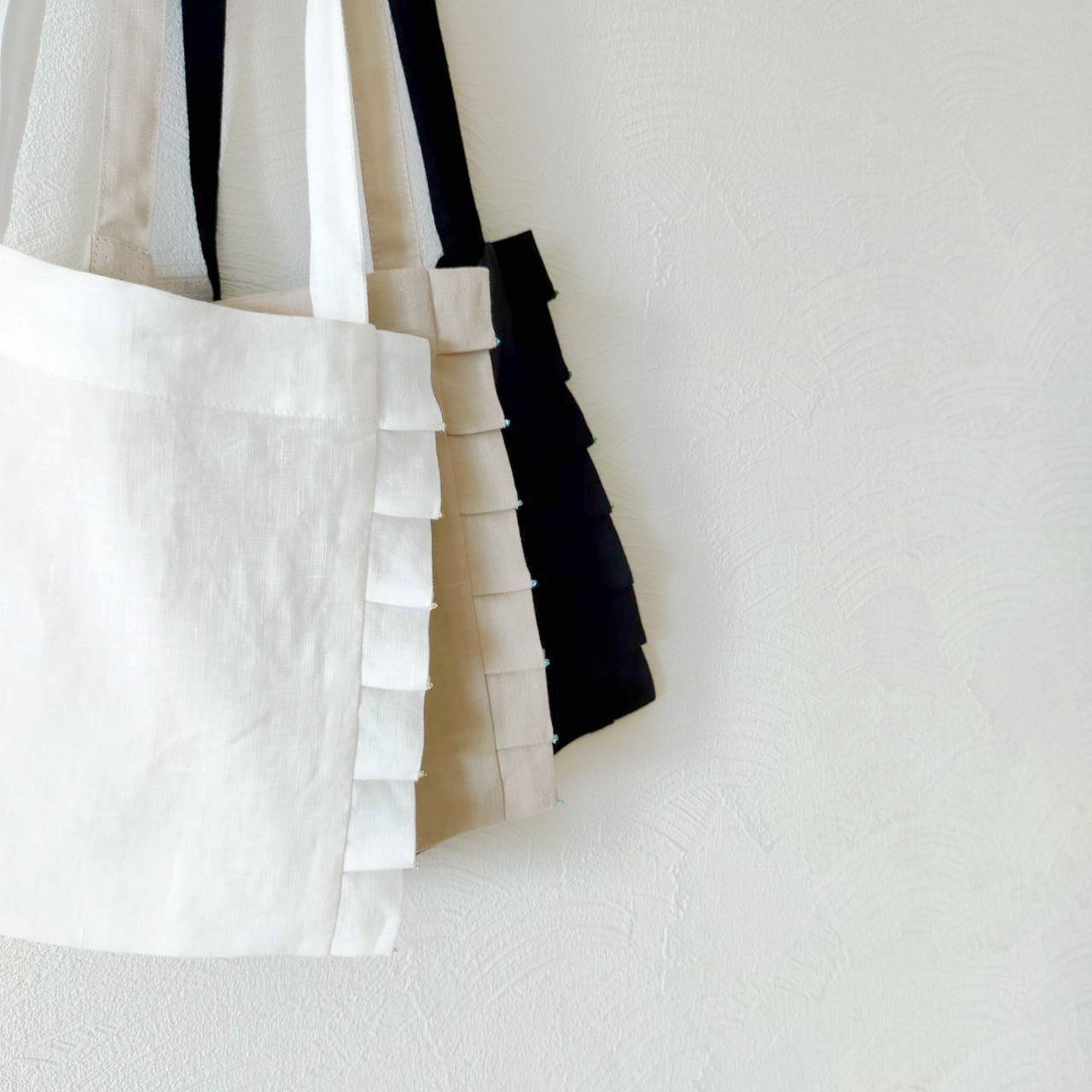Linen pochette with tuck frills and beads