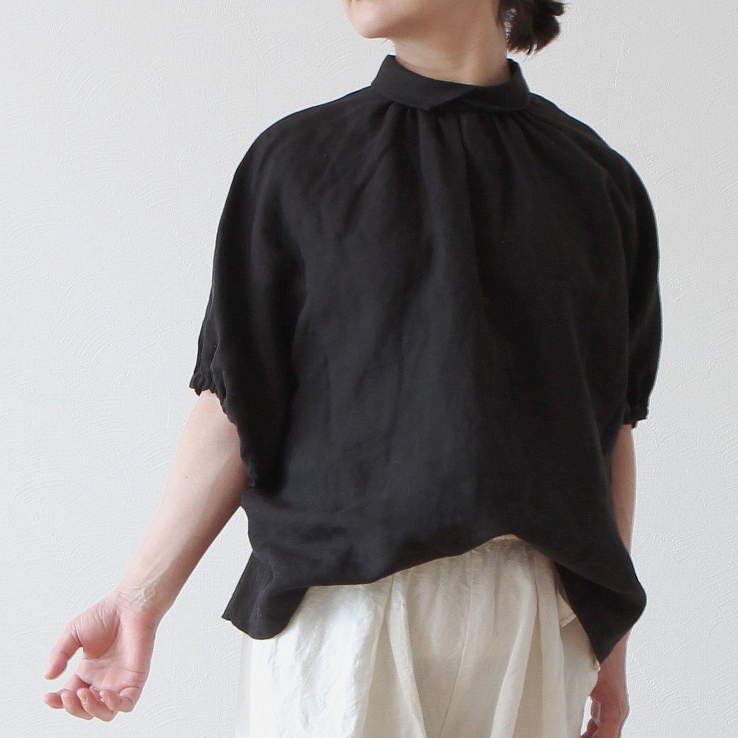 A sophisticated and cute clerical collar with back covered buttons and voluminous sleeves. French linen blouse with half-length sleeves/black