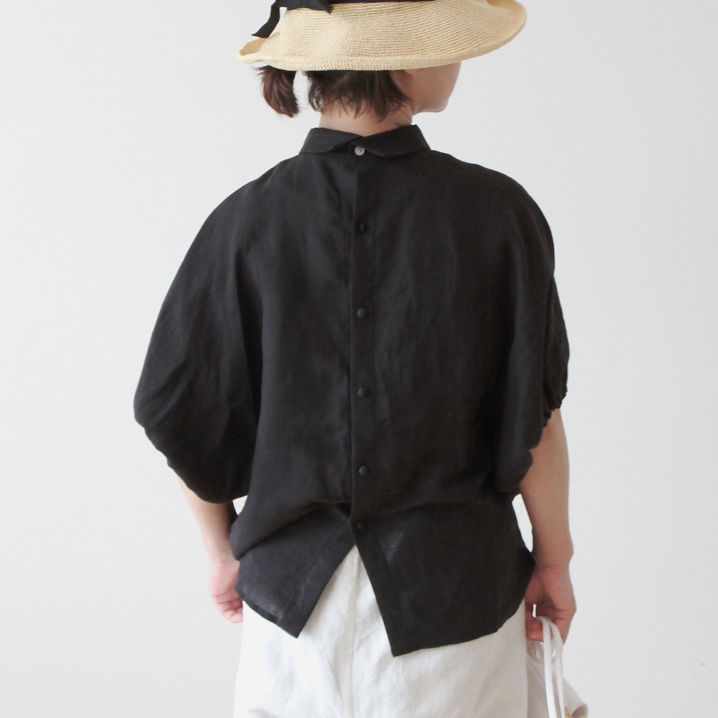 A sophisticated and cute clerical collar with back covered buttons and voluminous sleeves. French linen blouse with half-length sleeves/black