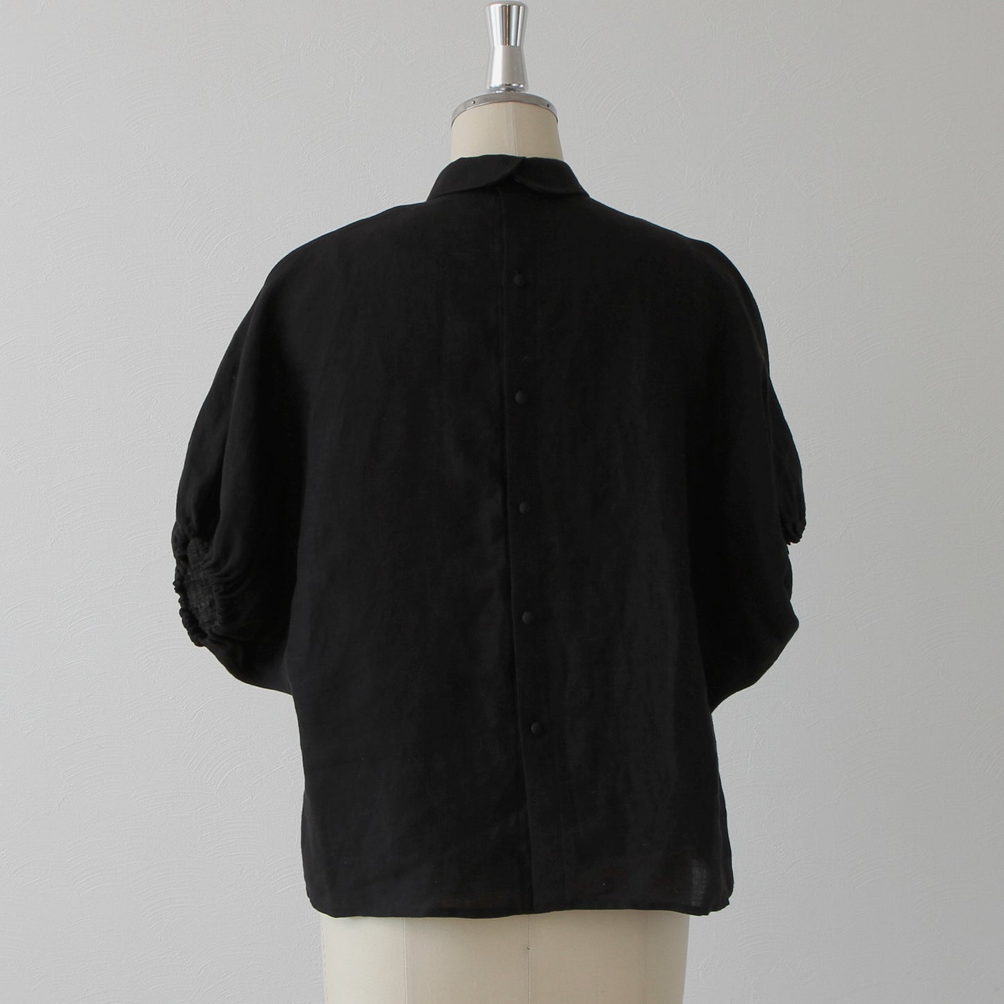 A sophisticated and cute clerical collar with back covered buttons and voluminous sleeves. French linen blouse with half-length sleeves/black
